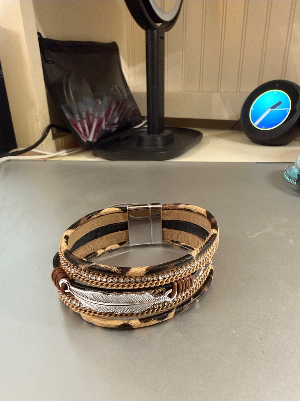 Magnetic close 7.5” animal print feather stack bracelet. NWOT